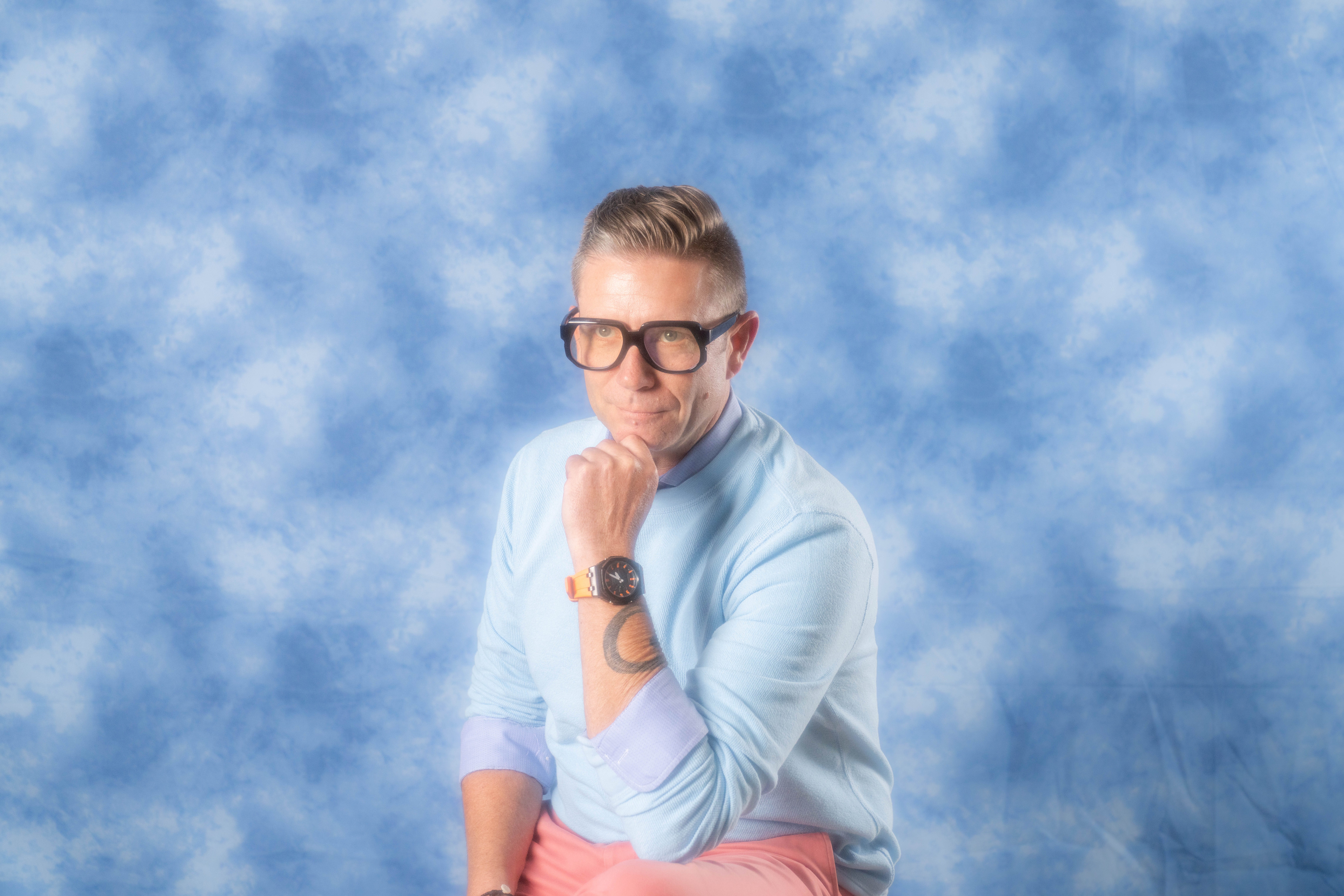 a man wearing glasses and a blue sky