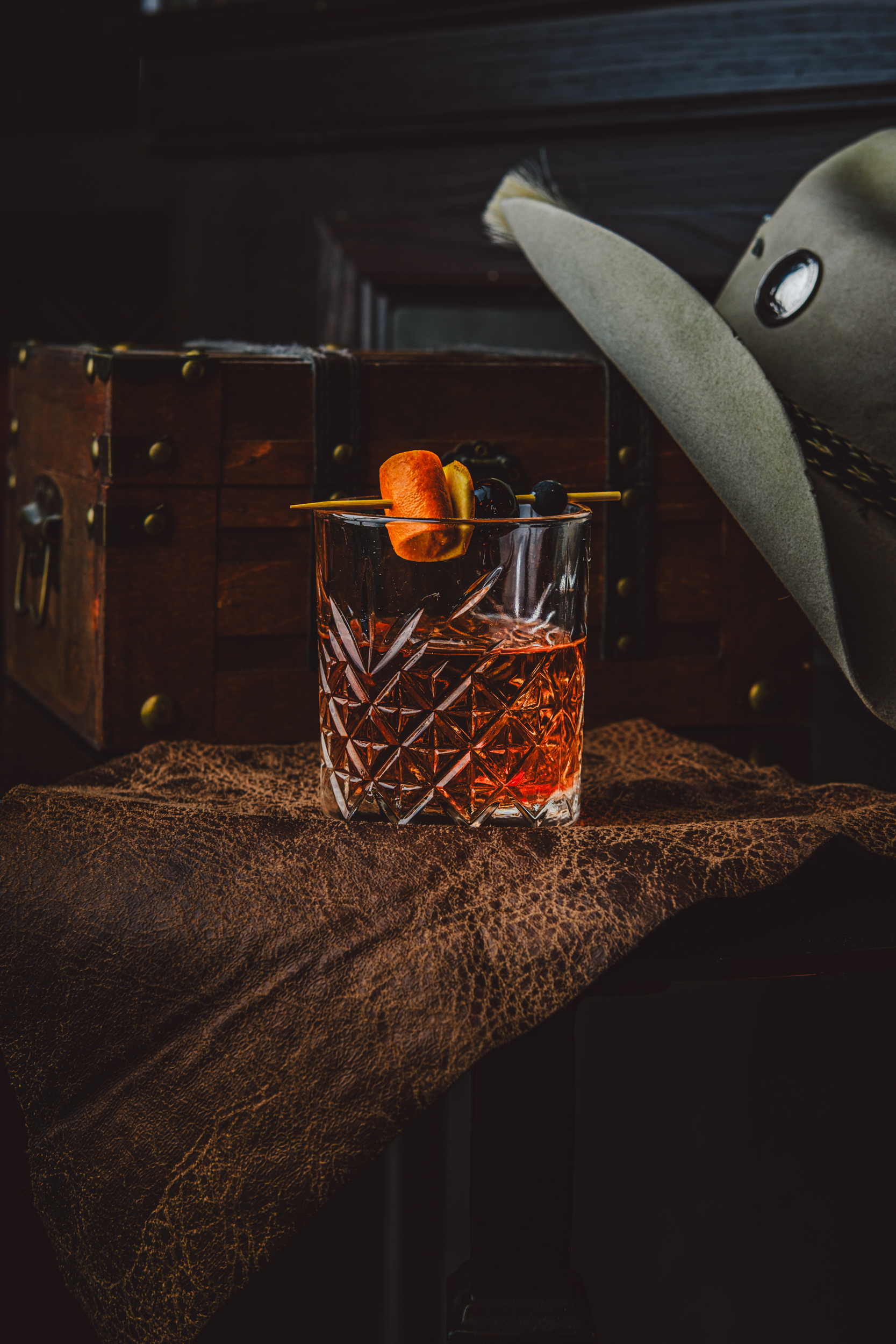 a glass with a drink and a hat on it