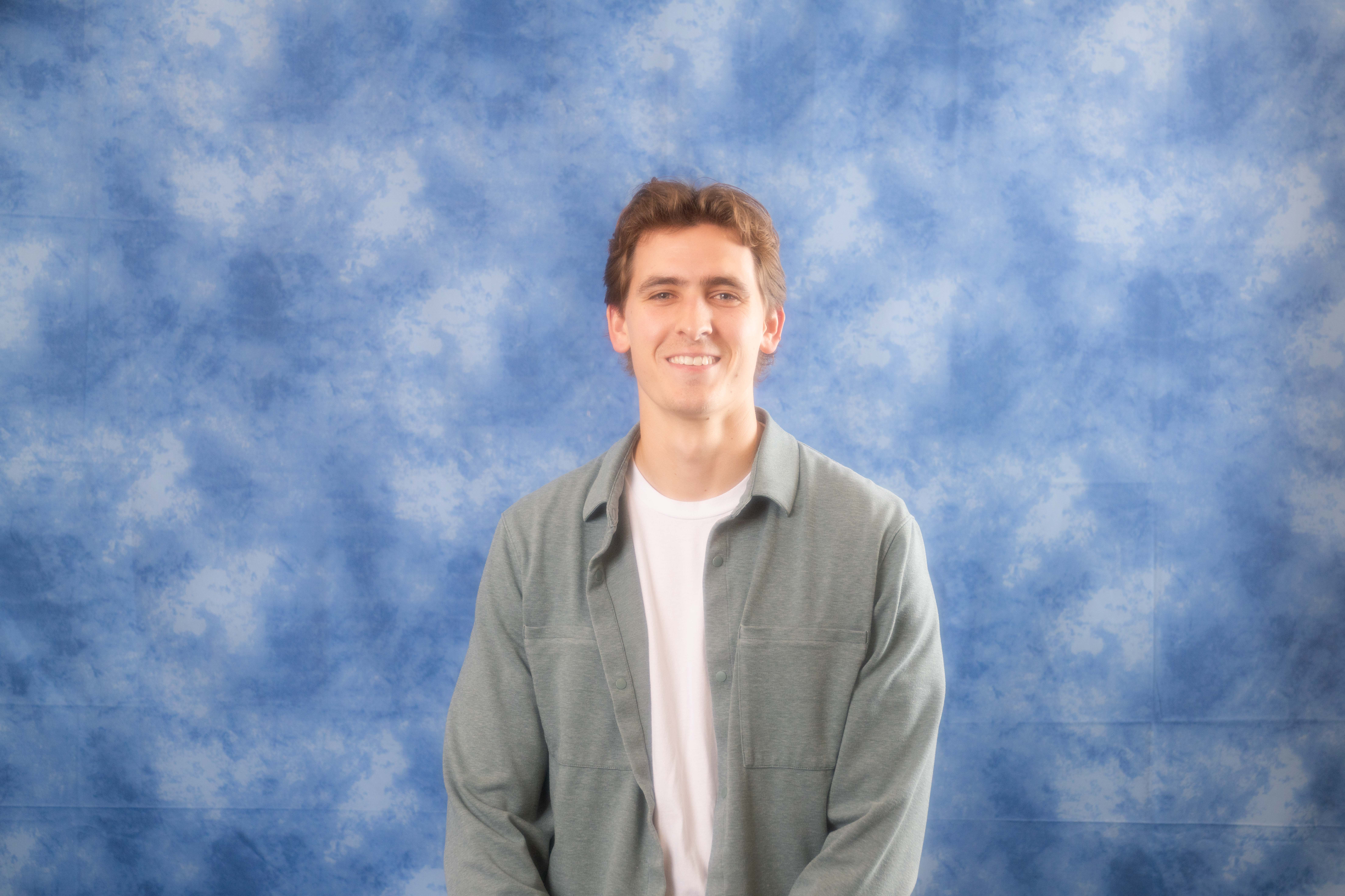 a man standing in front of a cloudy sky