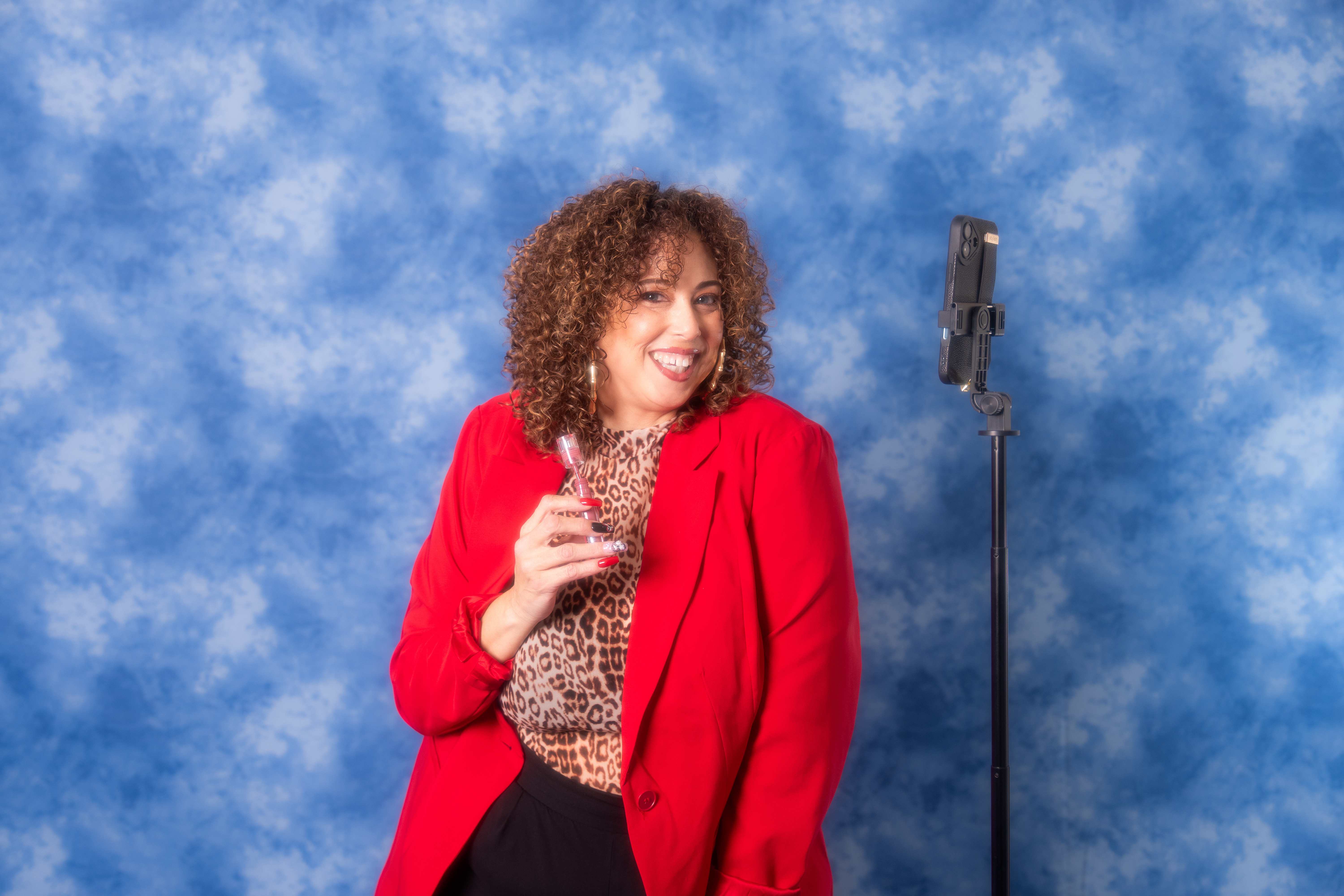 a woman in a red jacket holding a small bottle