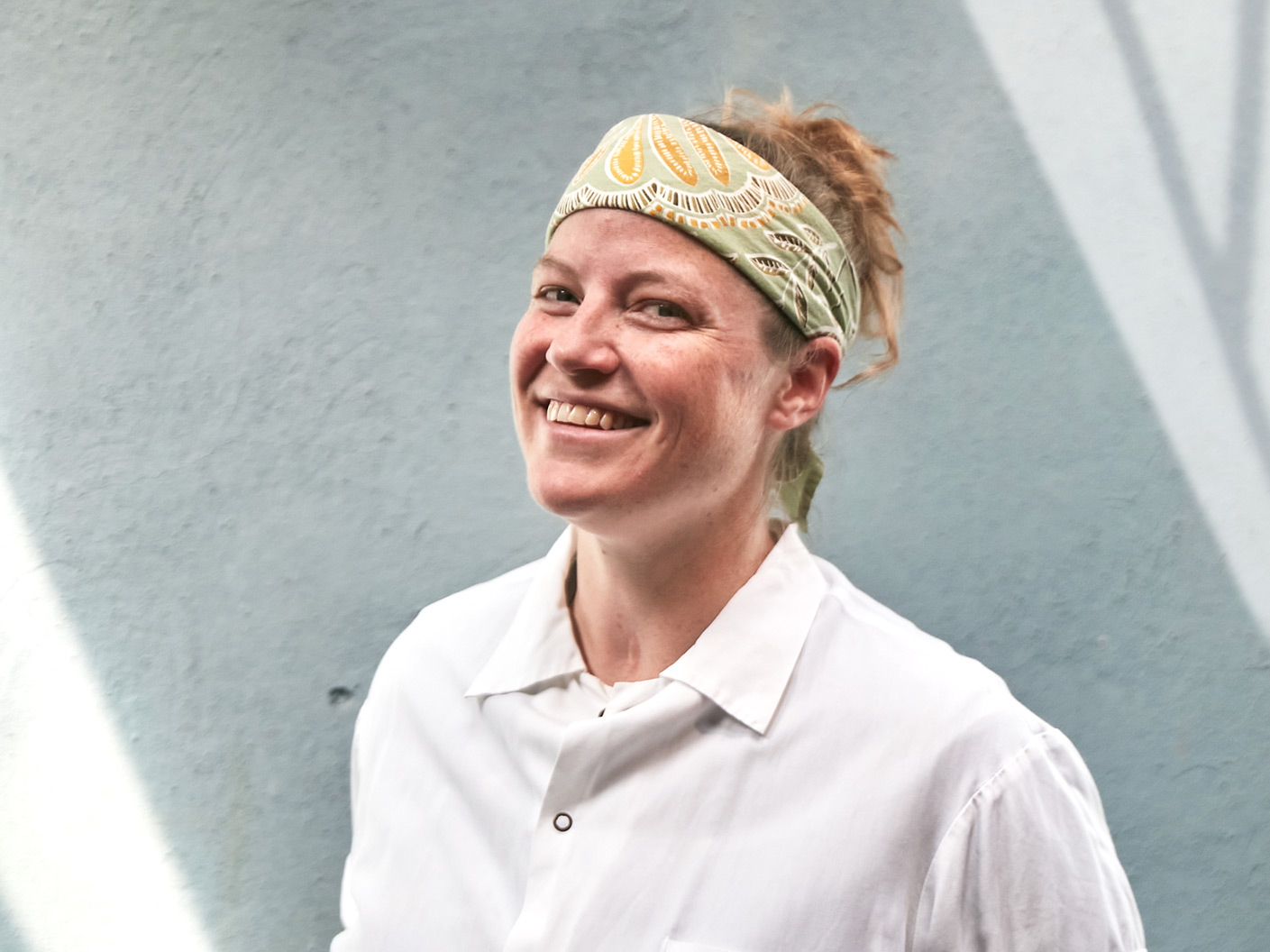 a man wearing a hat and smiling at the camera