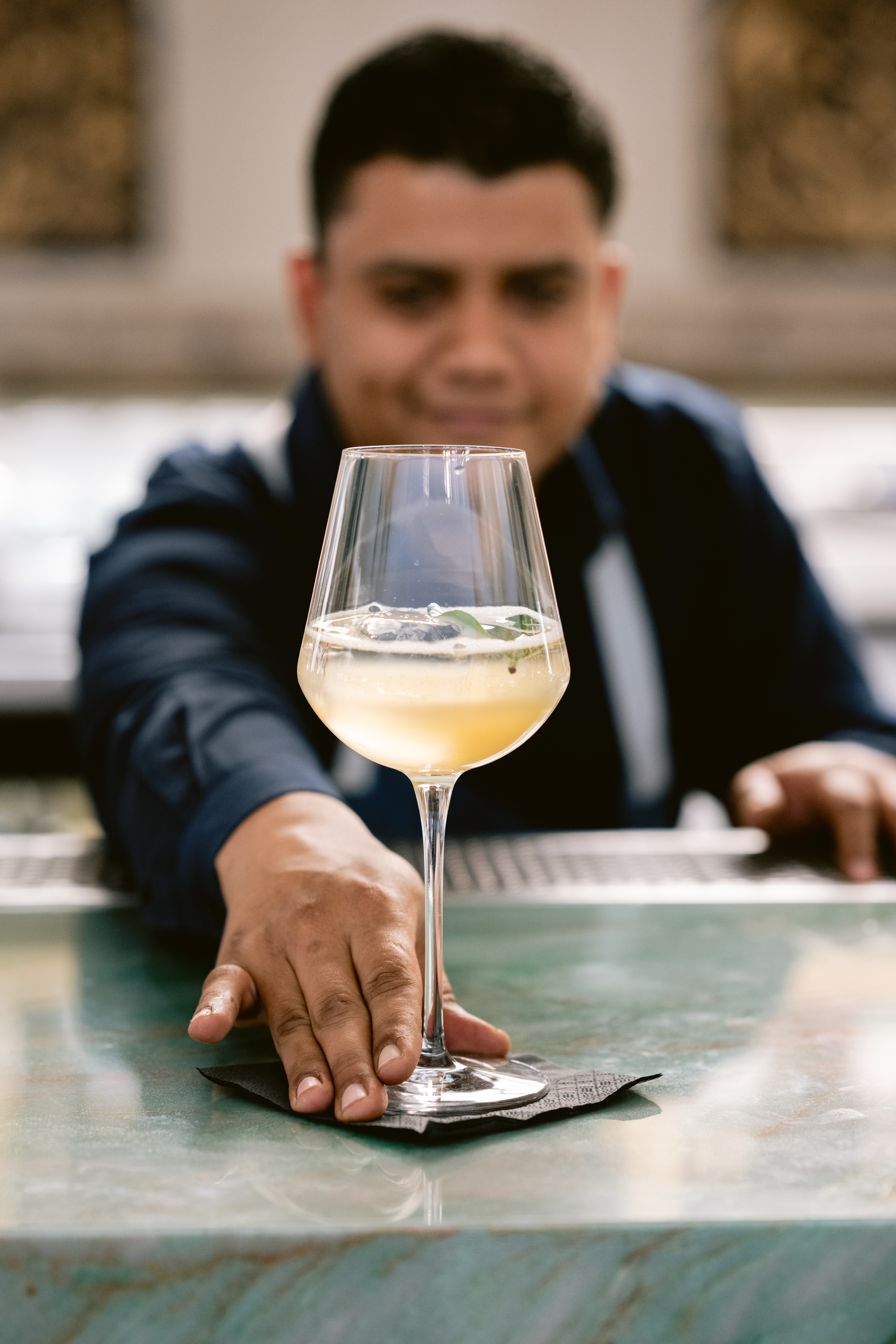 a person sitting at a table with a glass of wine