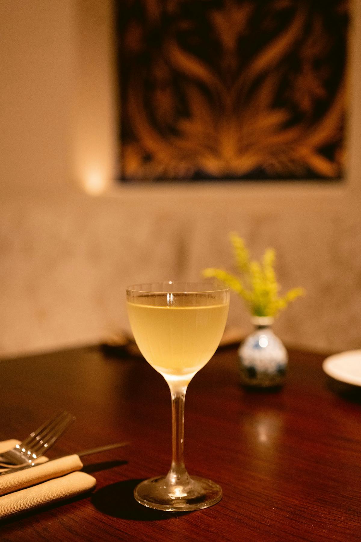 a glass of wine sitting on top of a wooden table