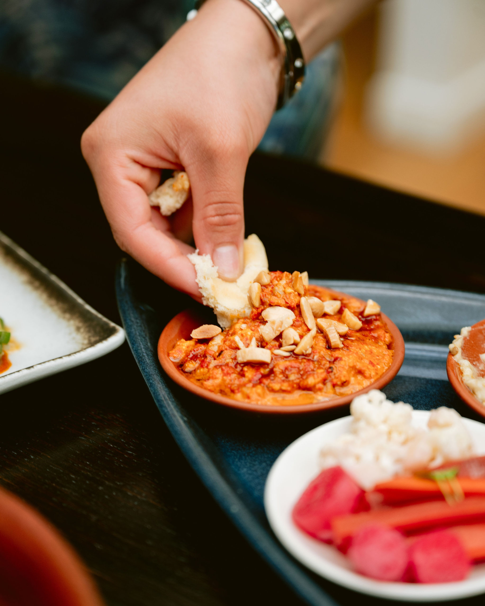 a person holding a plate of food on a table