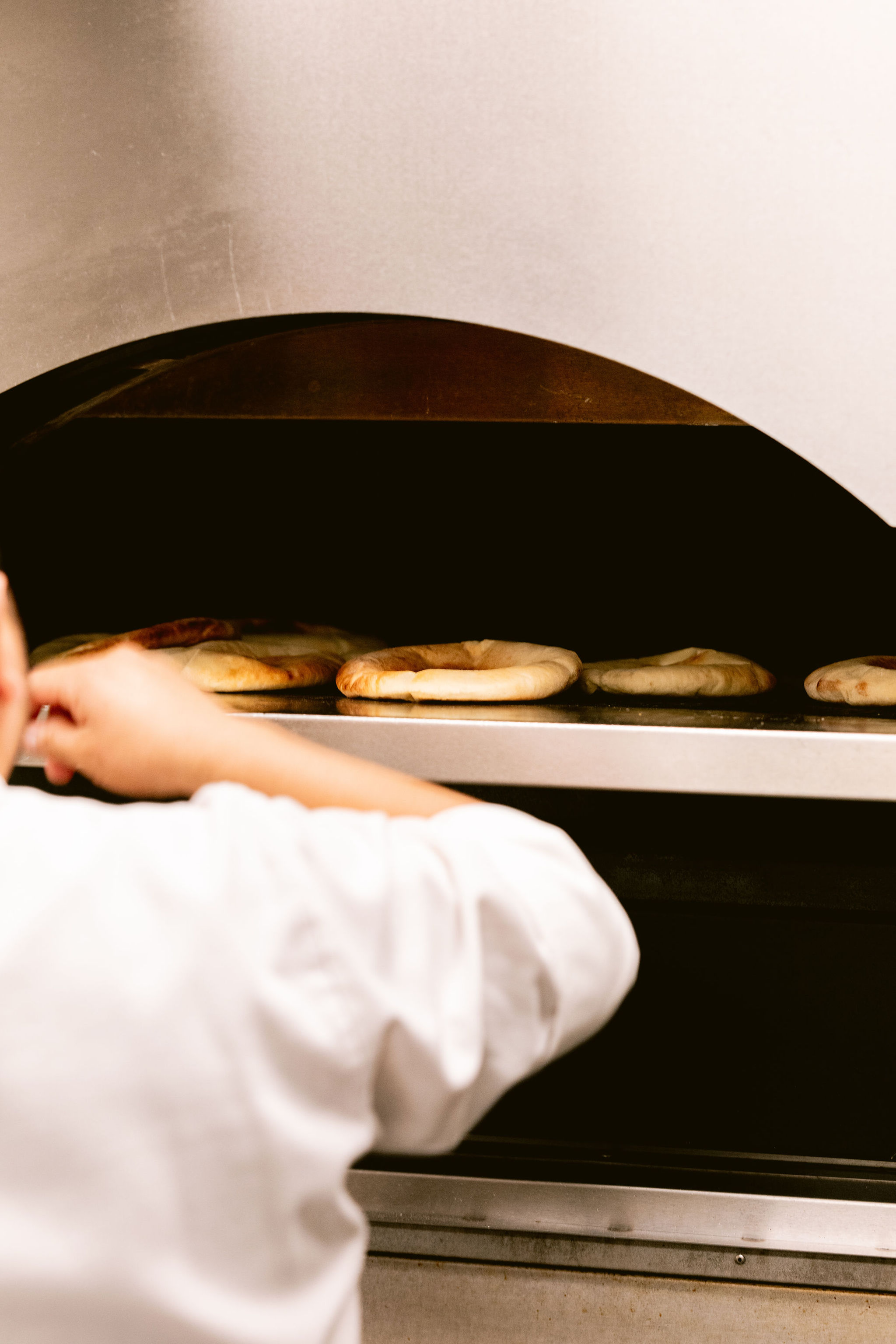 a person cooking bagels in a oven