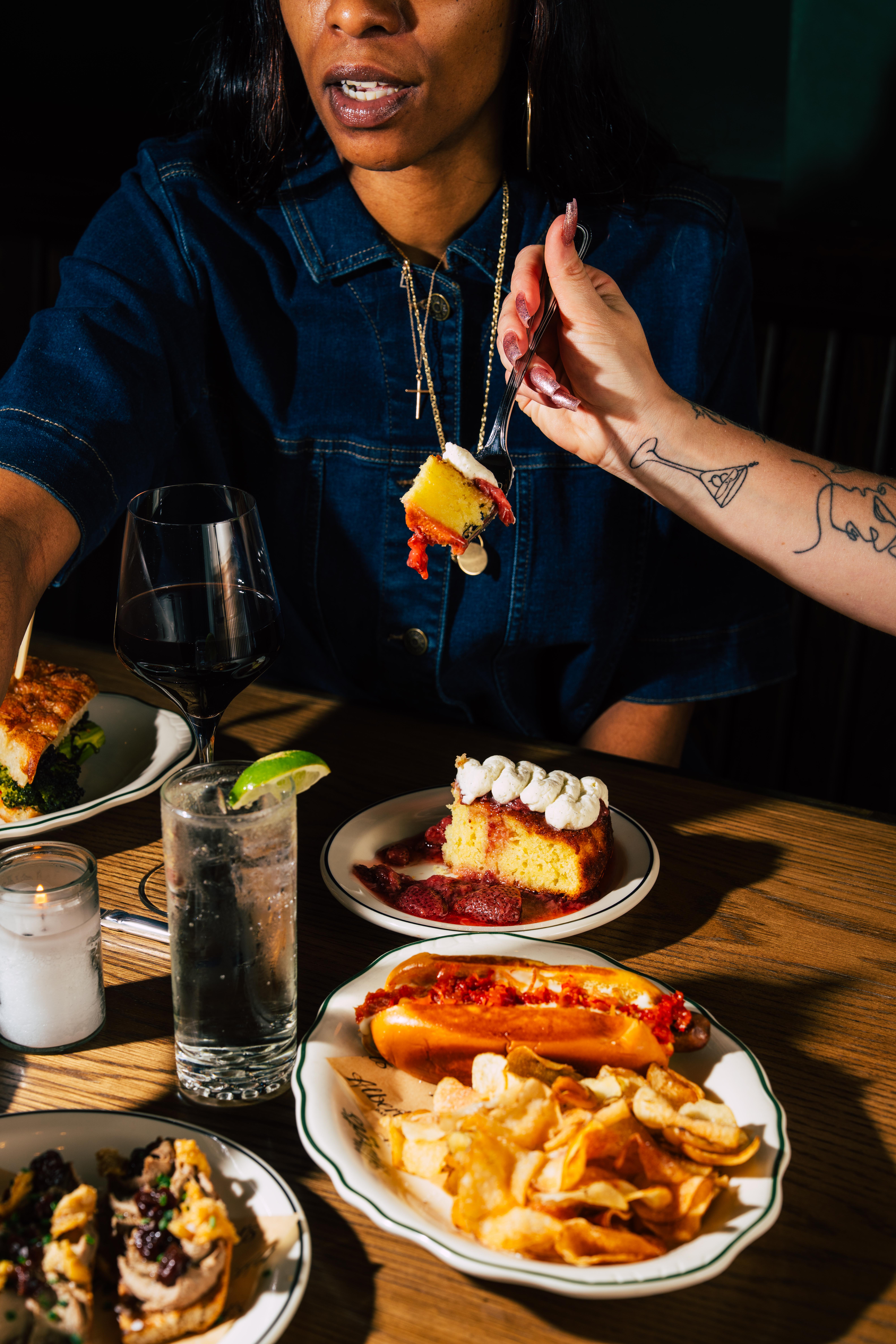 a woman biting into a cake seated at a table