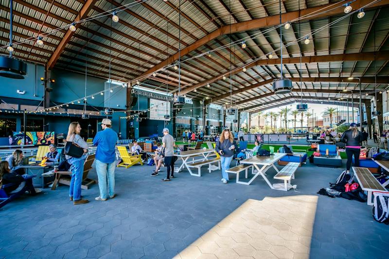 Guests hanging out under the covered outdoor Pickle Park at Dink & Dine Pickle Park