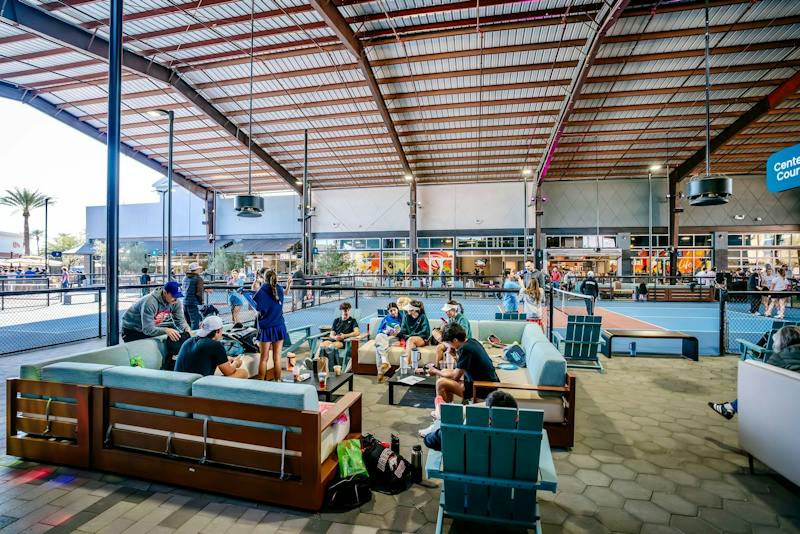 Groups hanging out on lounge sofas under the covered Pickle Park at Dink & Dine Pickle Park