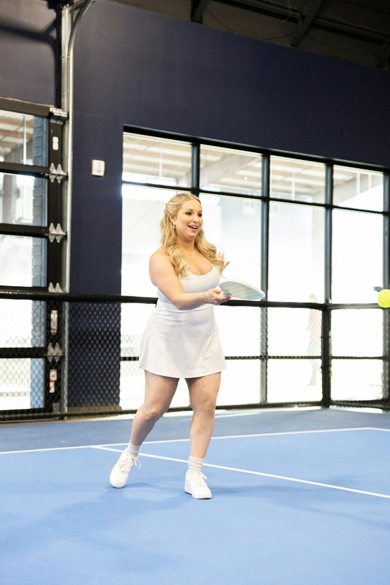 Bride playing pickleball on an indoor court at Dink & Dine Pickle Park