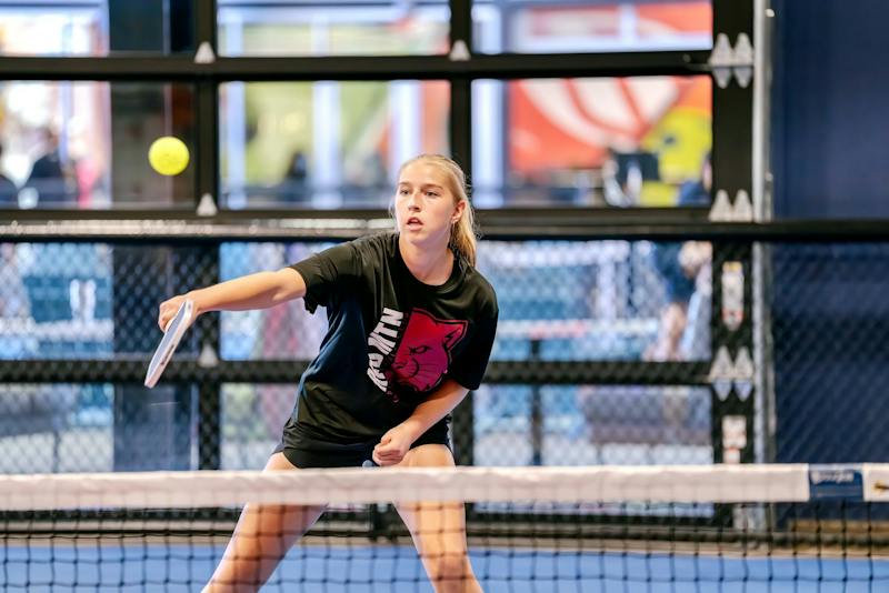 Player in the ready position during a rally at Dink & Dine Pickle Park