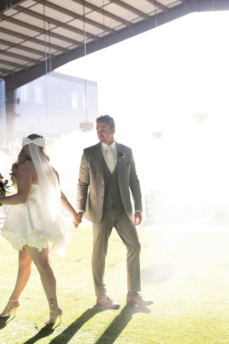 Bride and groom walking outdoors at Dink & Dine Pickle Park