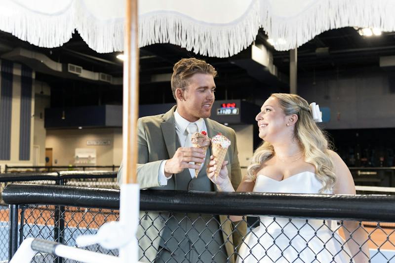 Couple sharing ice cream cones courtside at Dink & Dine Pickle Park