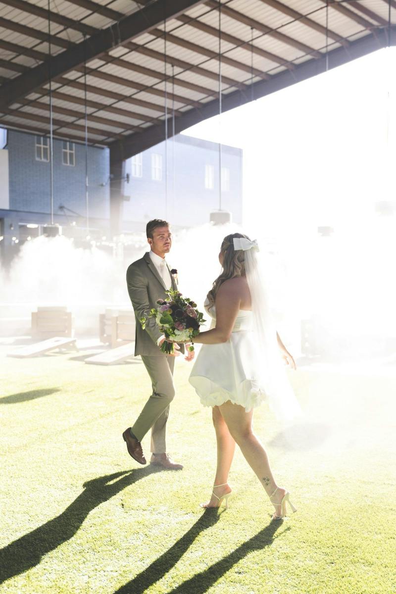 Bride and groom walking hand in hand at Dink & Dine Pickle Park
