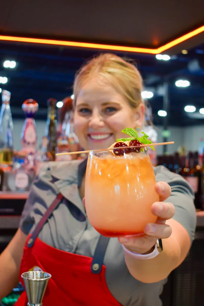 Bartender smiling and serving a craft cocktail