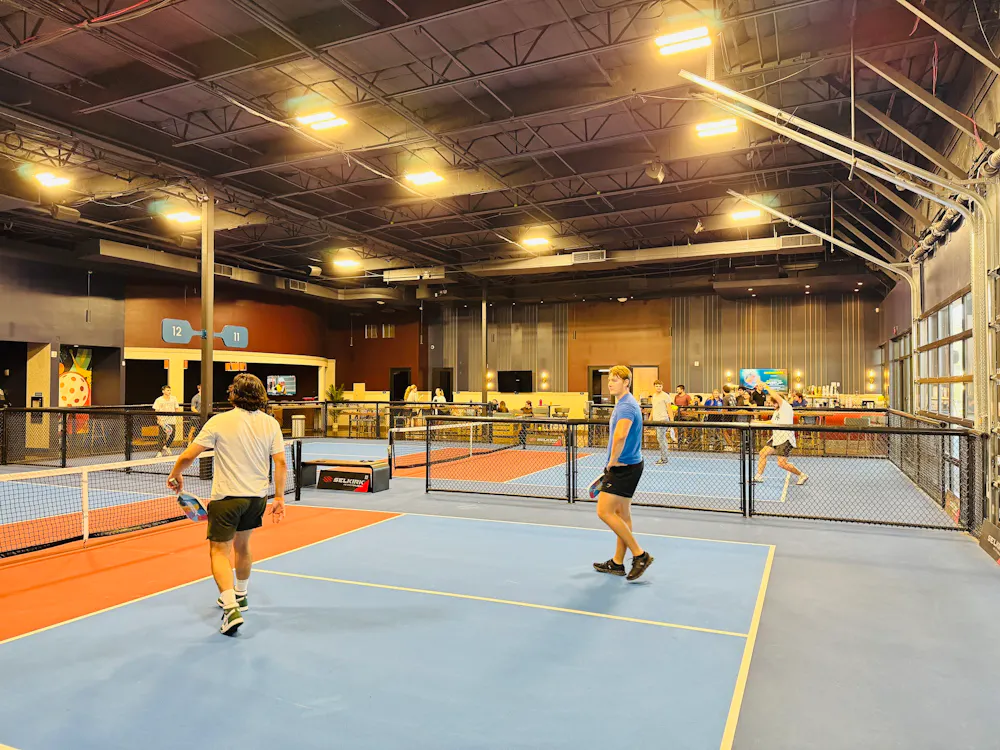 Players on the indoor Clubhouse courts with the bar in the background