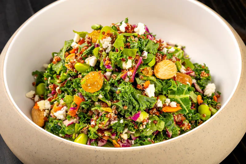 Fresh green salad in a white bowl from the Dink & Dine scratch kitchen