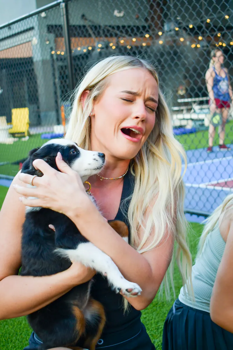 Guest laughing with a dog at the dog-friendly Pickle Park