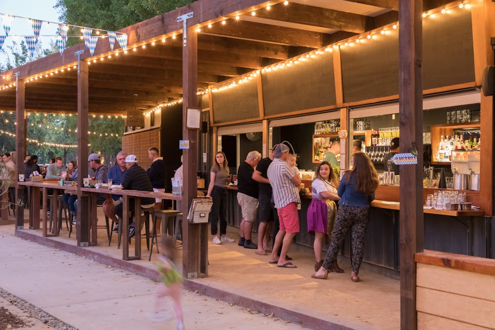 a group of people standing in front of a bar