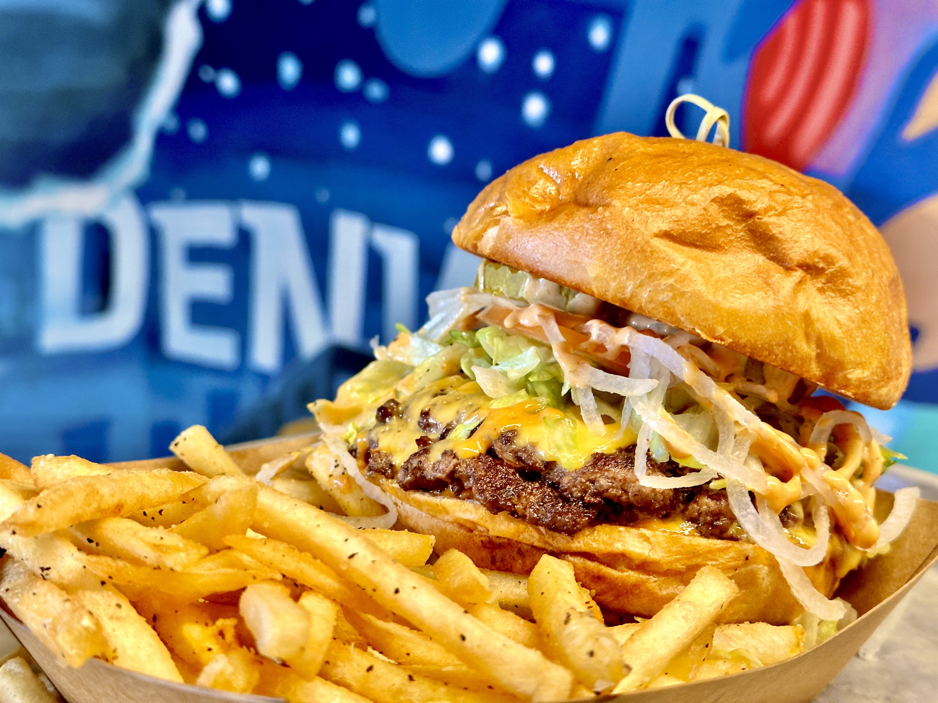 a close up of a sandwich sitting on top of a pile of fries
