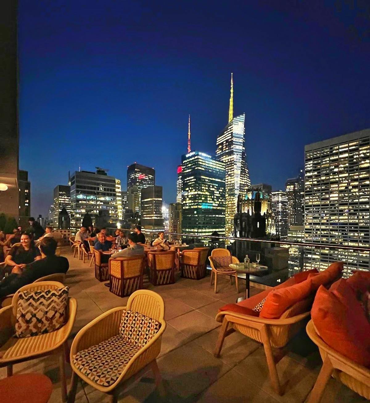 a group of people sitting at a table with a city in the background