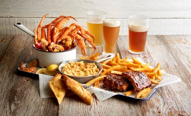 a plate of food and a glass of beer on a table