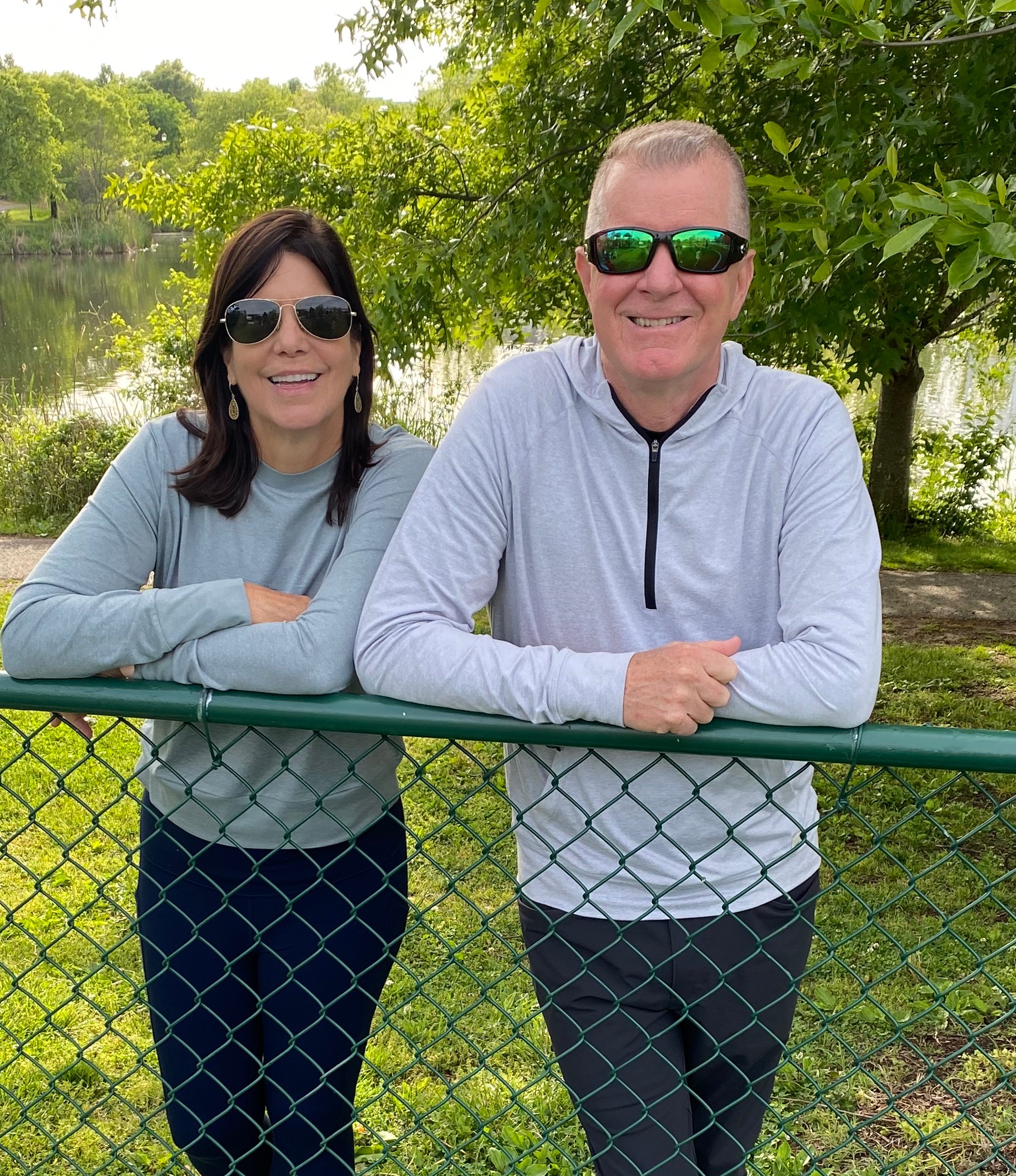 a man and a woman sitting on a bench posing for the camera