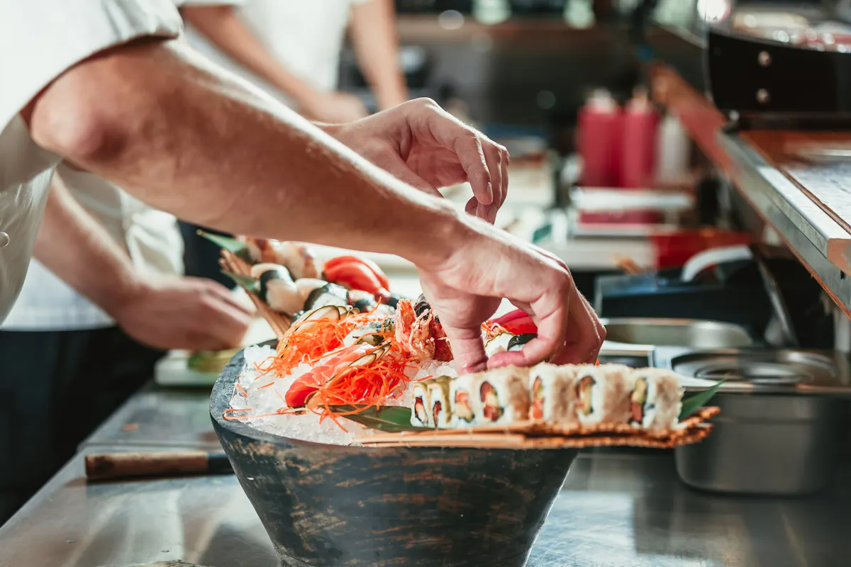people preparing plates of sushi