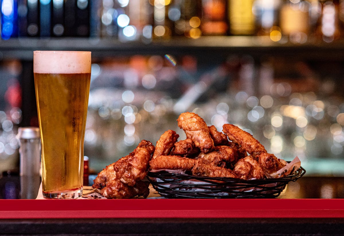 Image of a plate of wings next to a beer