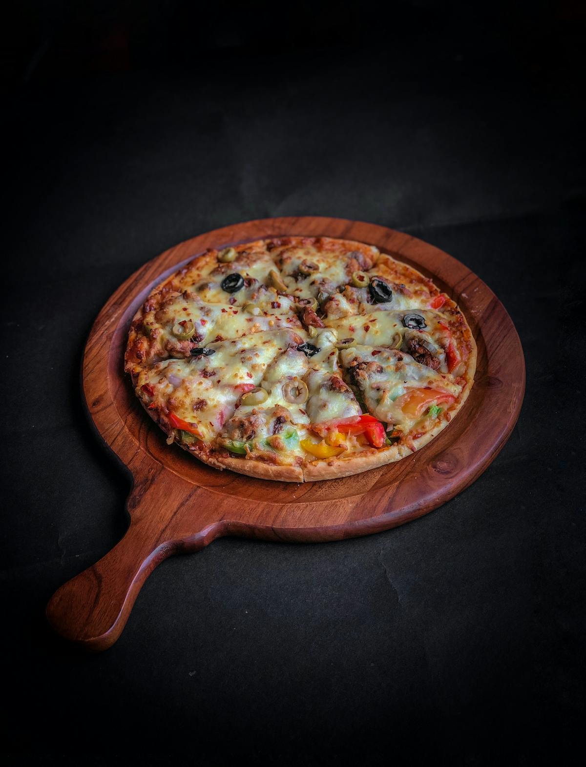 a pizza sitting on top of a wooden table