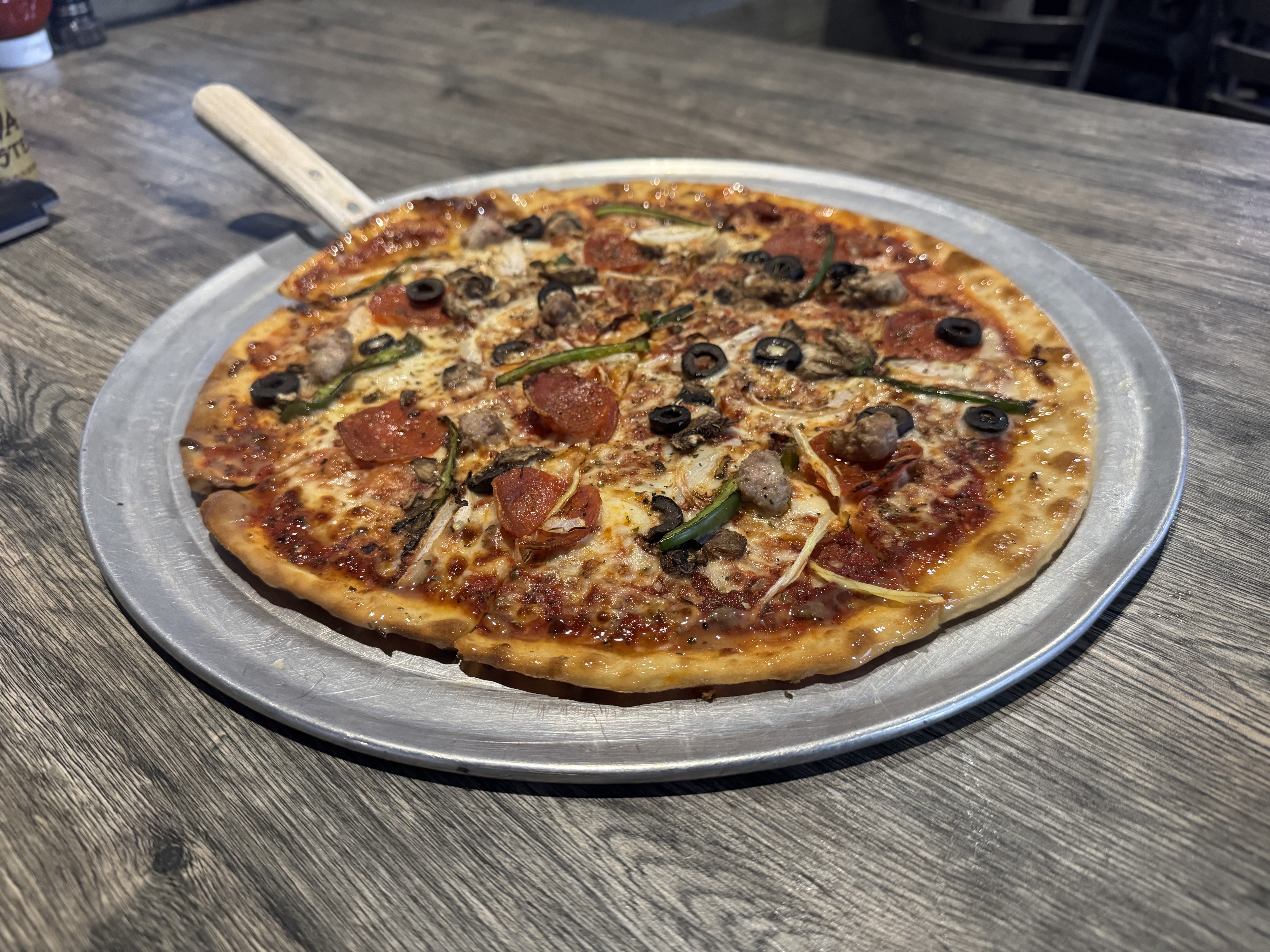 a pizza sitting on top of a wooden table