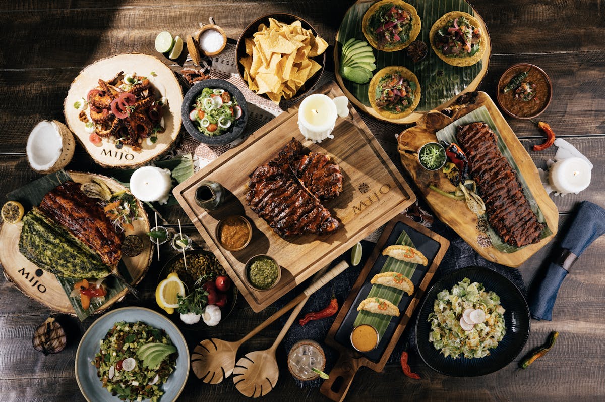 Overhead view of Mijo Modern Mexican signature dishes including grilled steaks, tacos, ribs, fresh guacamole, chips, and vibrant Mexican cuisine at Durango Casino & Resort in Las Vegas.