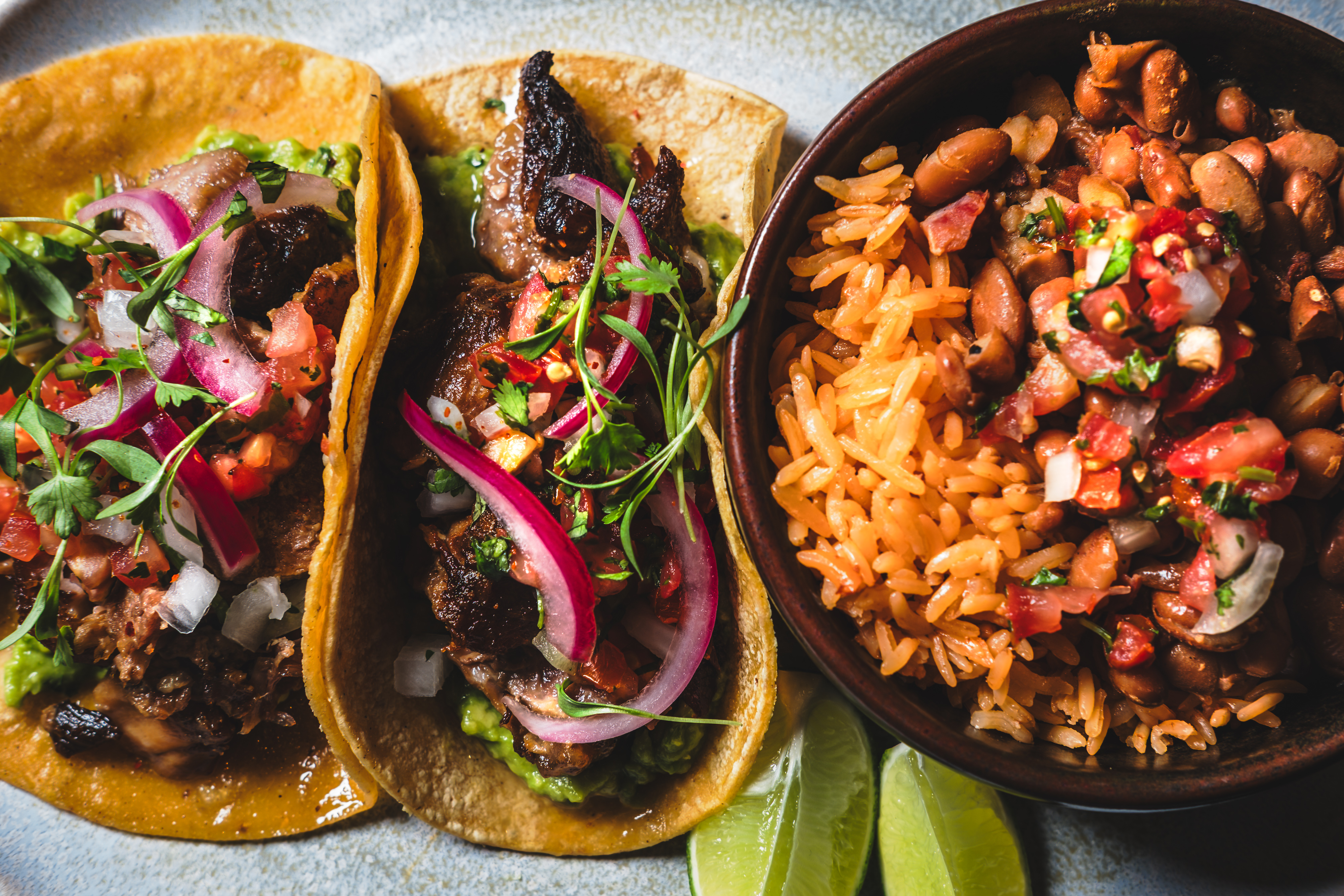 a photo of carnitas tacos with rice and beans served at mijos taco Tuesday which launches on august 5th at the Las Vegas mexican restaruant