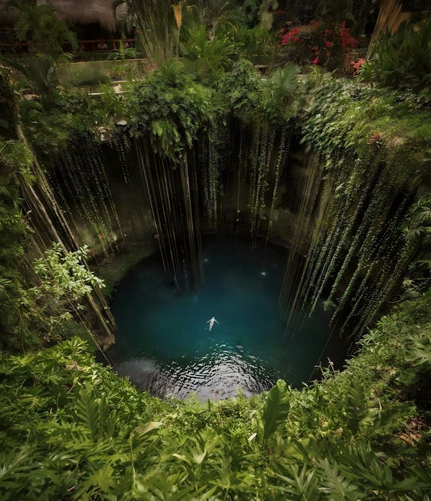 a large waterfall in a forest with someone floating in it