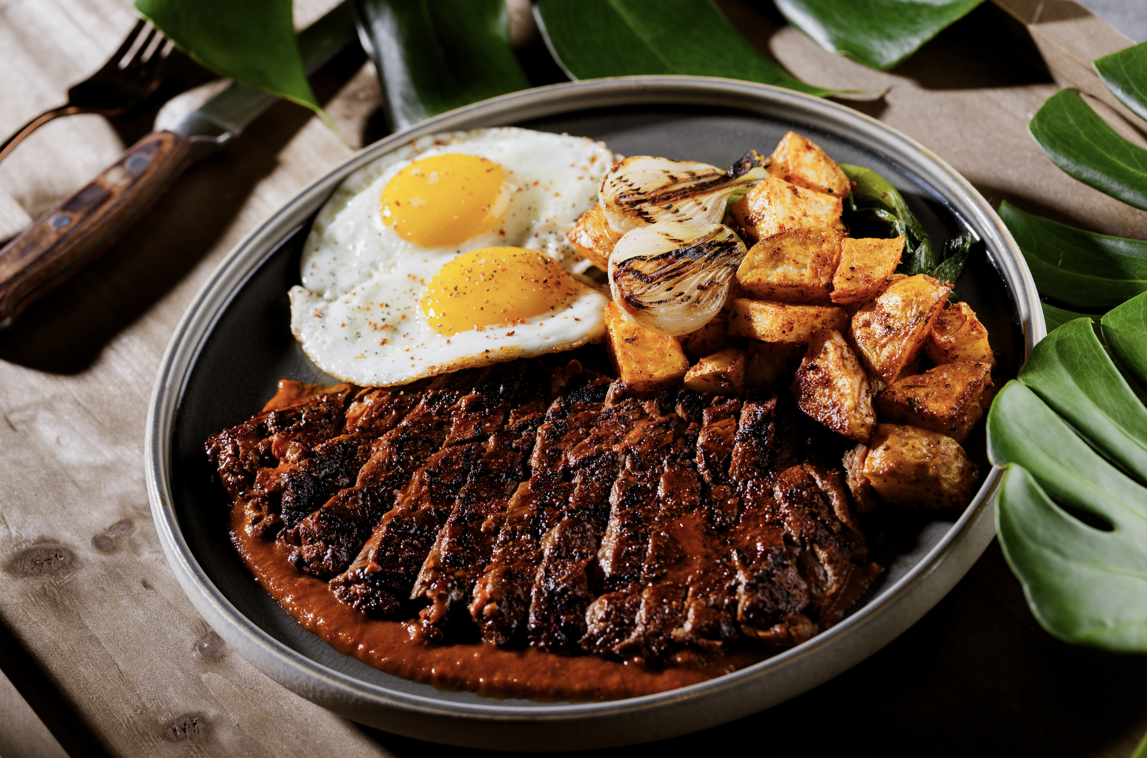 Ranchero steak and eggs with crispy breakfast potatoes and grilled onions at Mijo Modern Mexican, a Mexican Summerlin restaurant serving hearty Mexican brunch and one of the best brunch experiences in Las Vegas.
