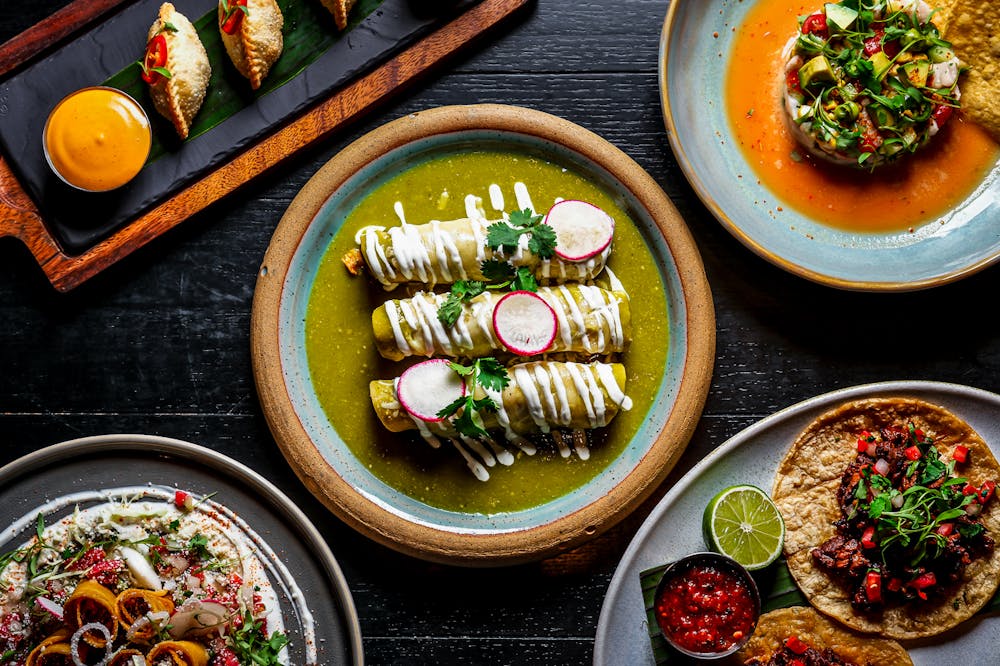 Colorful spread of modern Mexican dishes including tacos, enchiladas, ceviche, and appetizers served family-style at Mijo Modern Mexican brunch in Las Vegas.