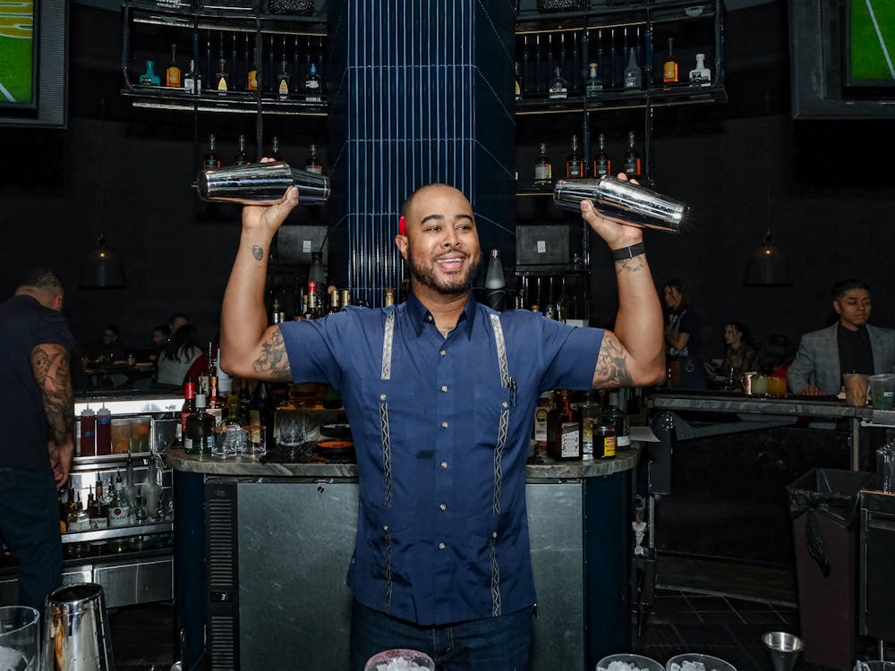 bartender at Mijo shaking two cocktails behind the bar at the Las Vegas Mexican food restaurant