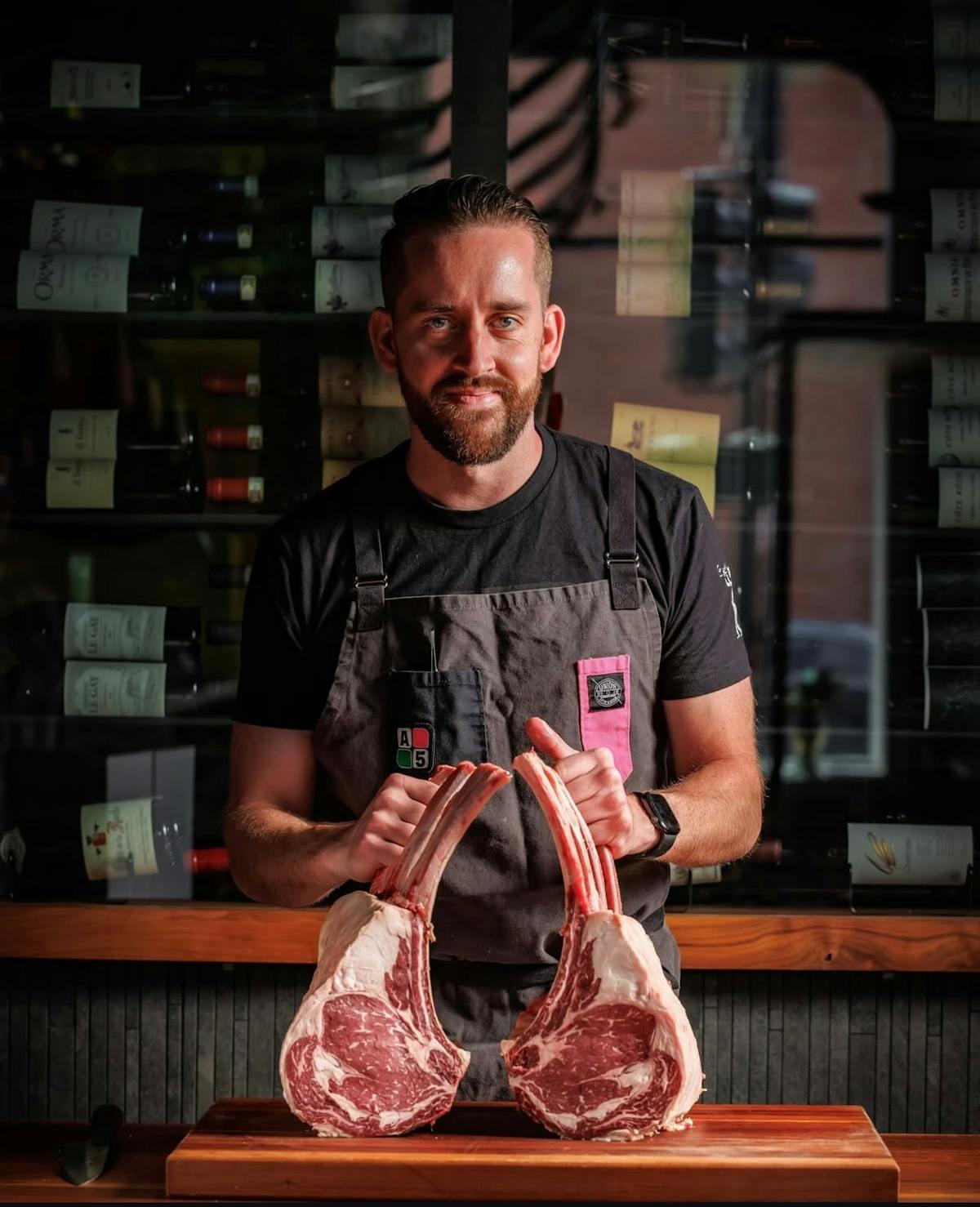 a man holding meat on a table