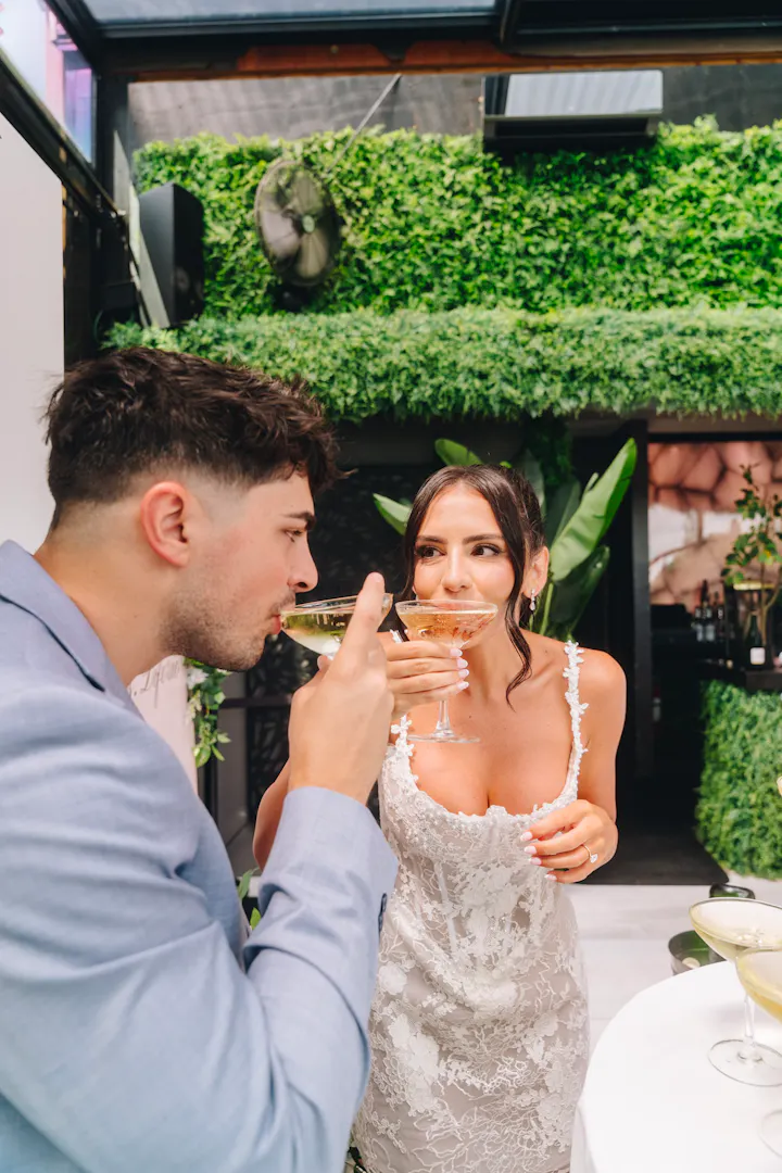 Guests toasting beneath the greenery at Gigante