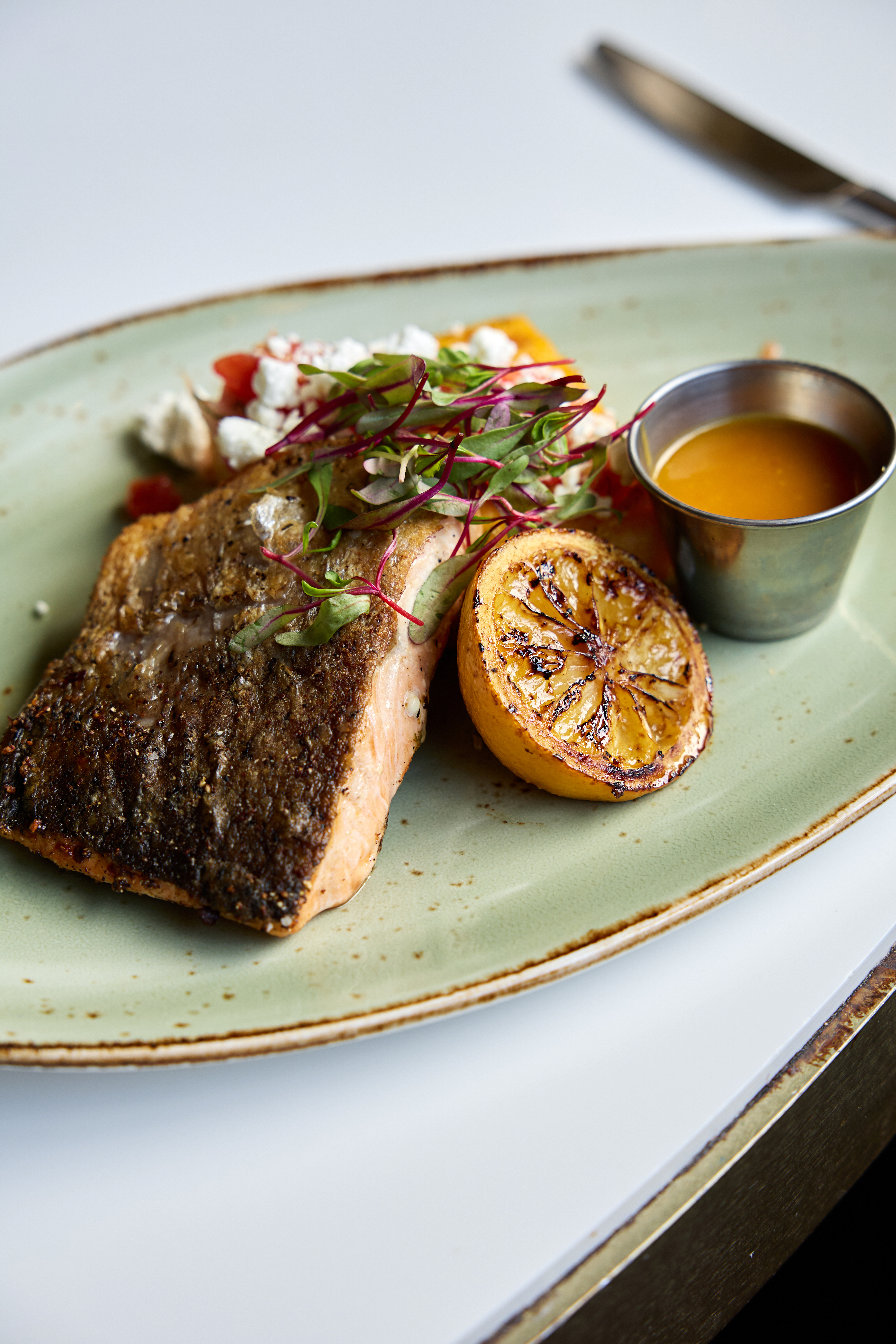 a plate of food with a lemon wedge and sauce