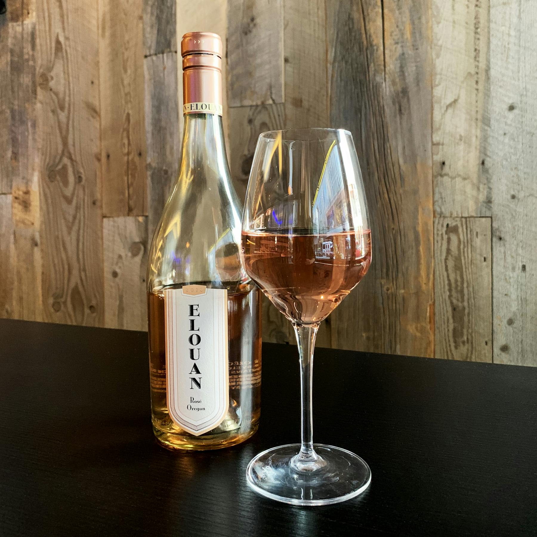 a bottle of wine sitting on top of a wooden table