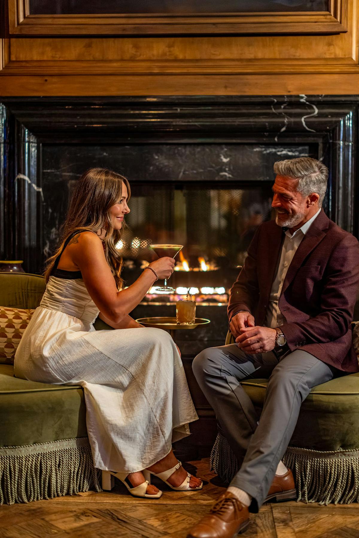 couple by fire with cocktails