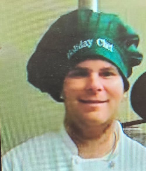 a man wearing a hat and smiling at the camera