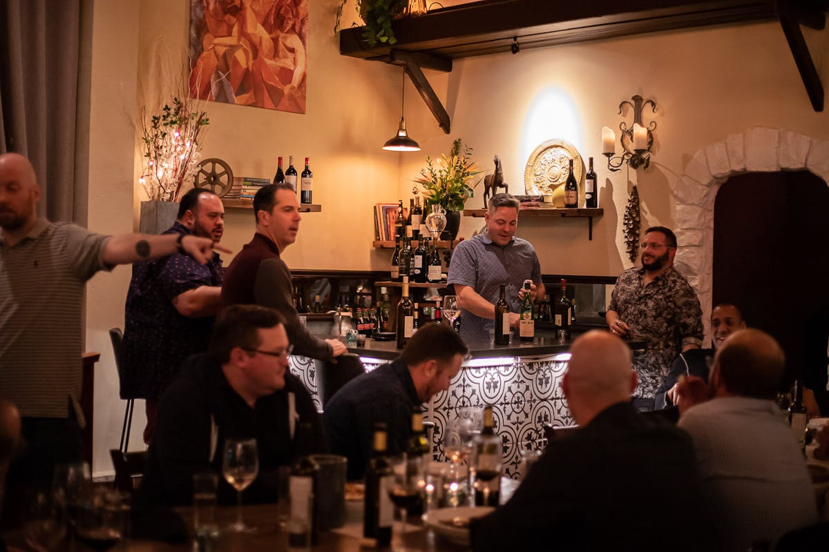 a group of people sitting at a table with wine glasses