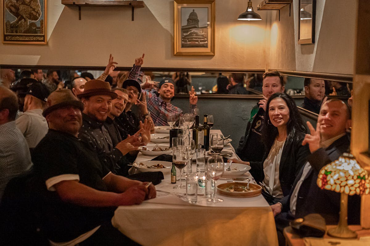 a group of people sitting at a table with wine glasses