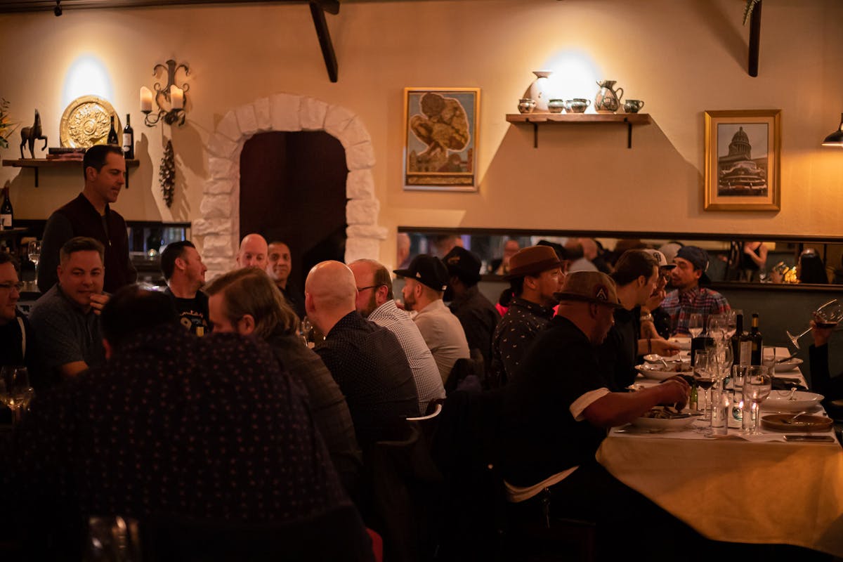 a group of people sitting at a table with wine glasses