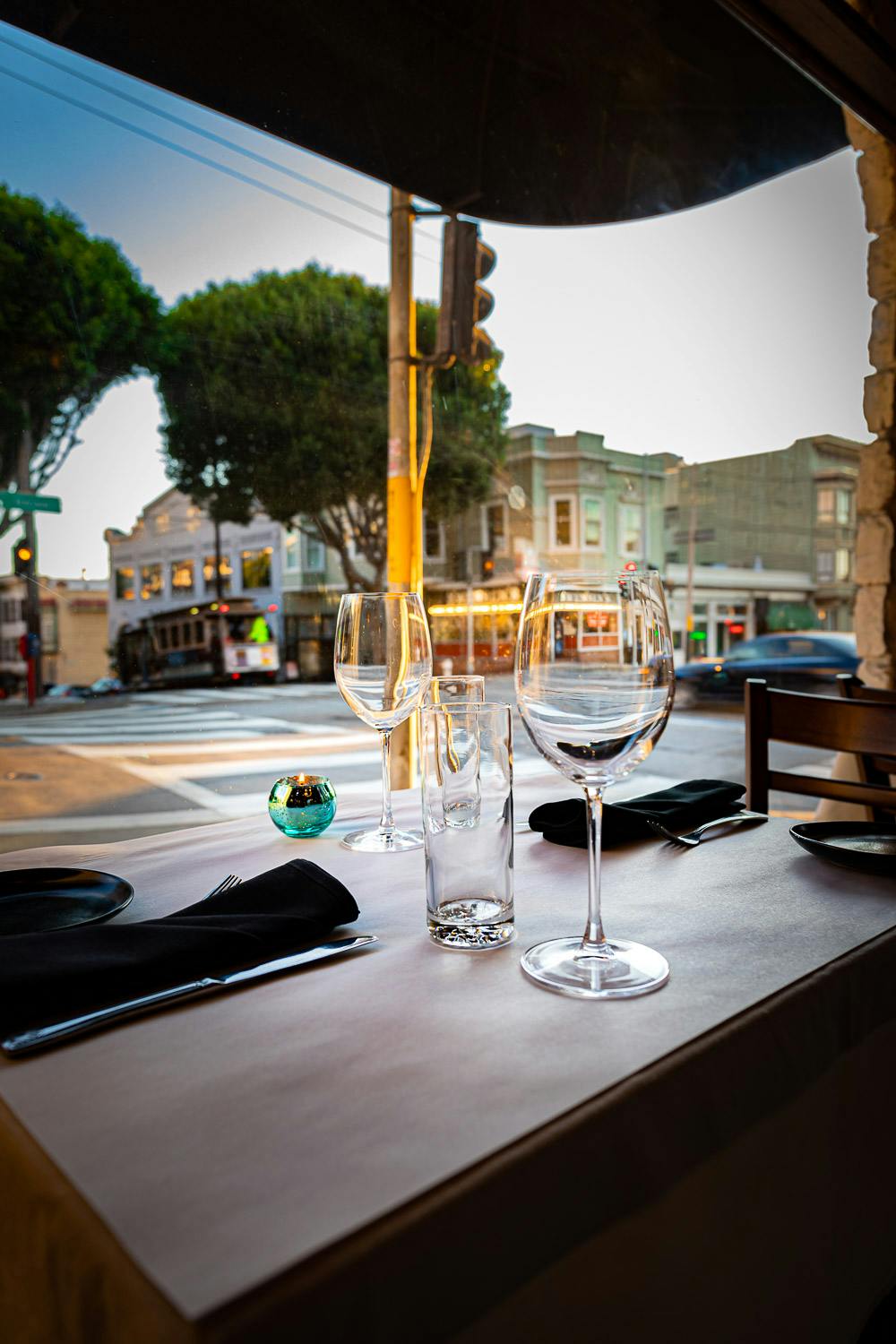 a dining table next to a glass of wine