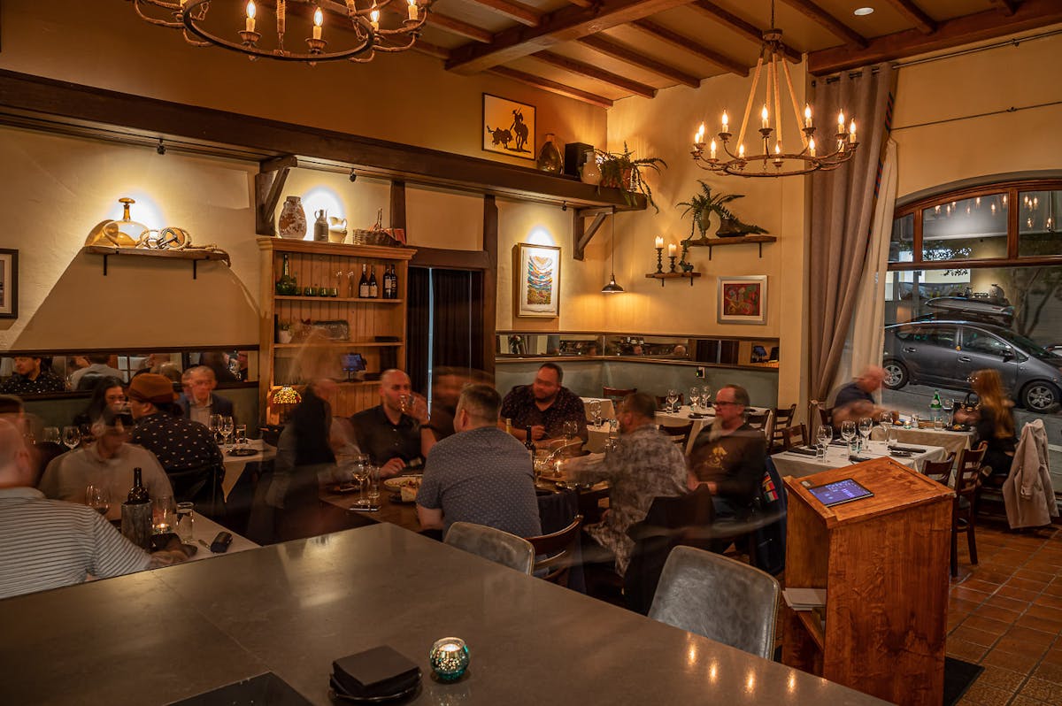 a group of people sitting at a table in a restaurant kitchen