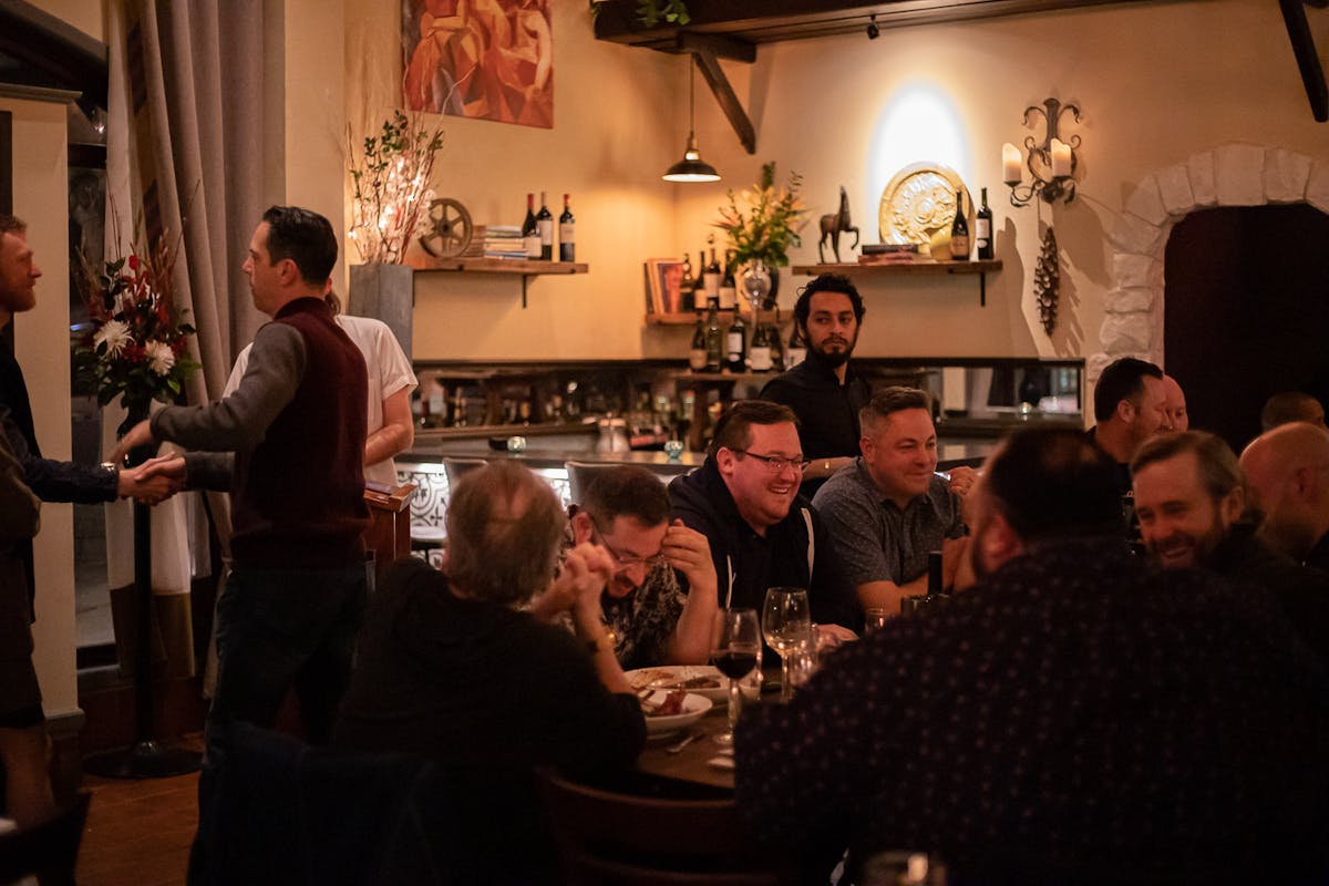 a group of people sitting at a table with wine glasses