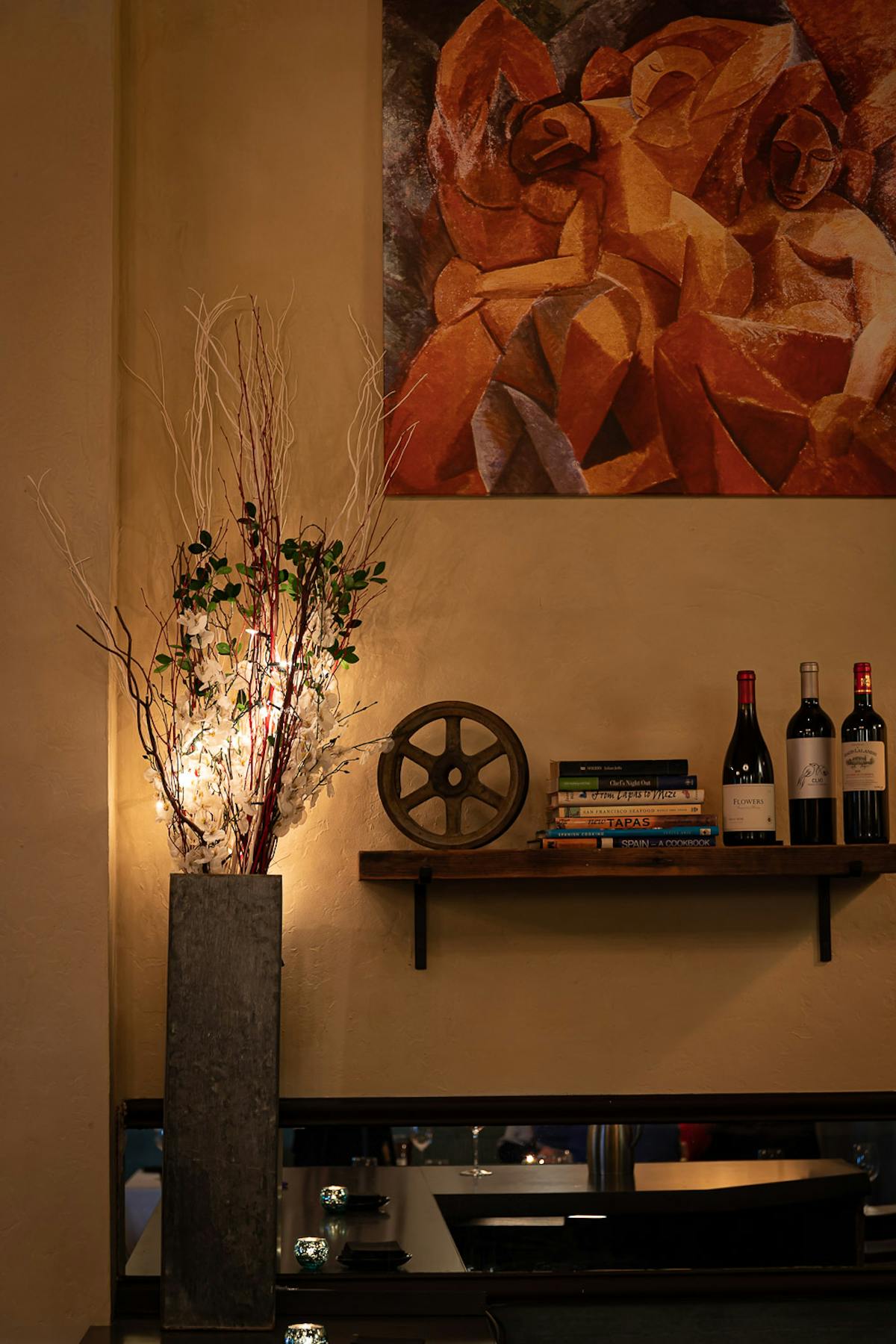 a vase with flowers in front of a mirror