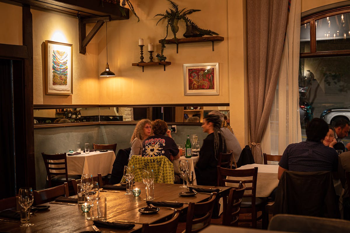 a person sitting at a table with wine glasses